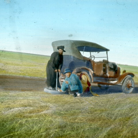 Flat tyre of an SMB missionary (name unknown) on a dirt road. (coloured, SMB archive, FDC 118/229)