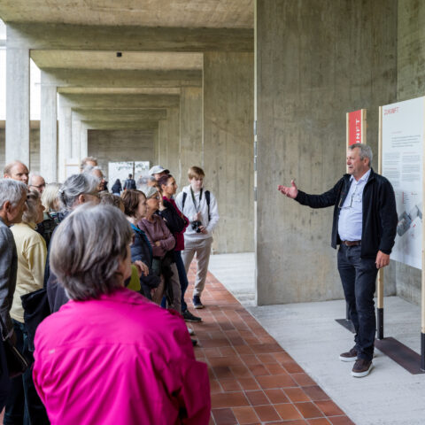 Stefan Kaiser von der Baukommission stellt den Besuchern auf einer Führung das Wohnbauprojekt vor.